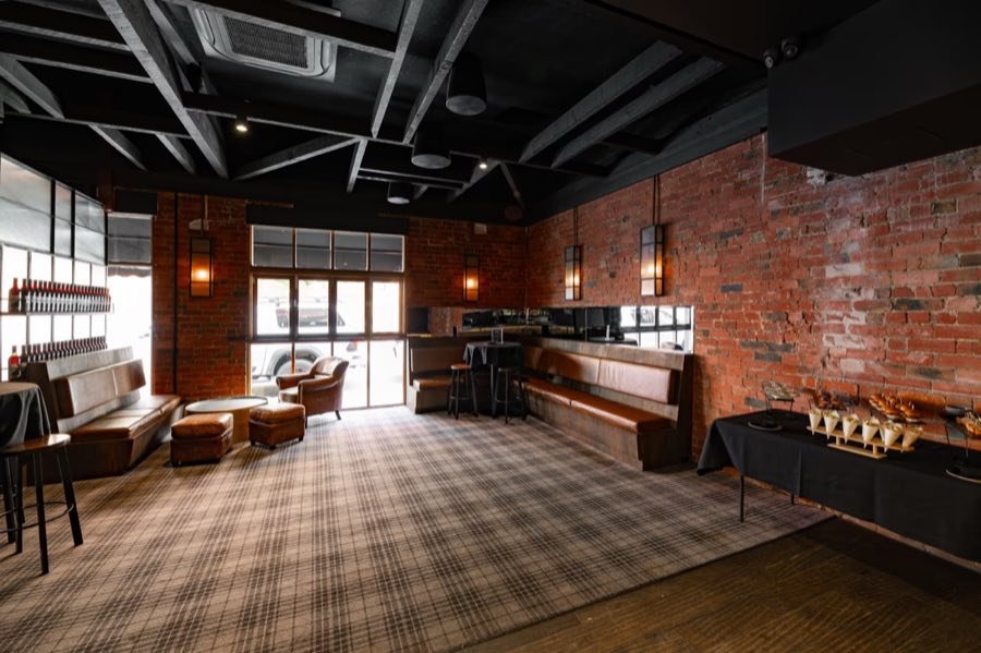 Brick walls, leather booths and plaid carpet inside Penny Young Bar